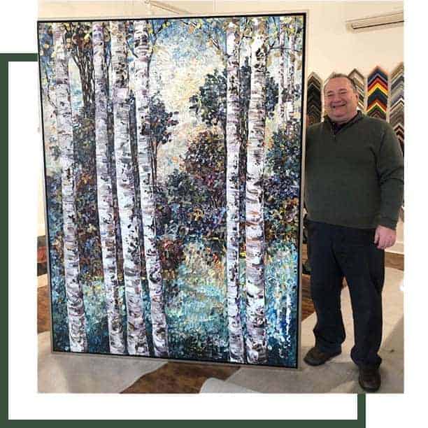 Photo of Paul Mahoney next to large framed painting.